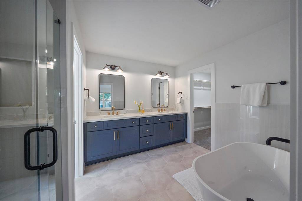 The primary bathroom offers dual sinks, soaking tub and enclosed water closet.