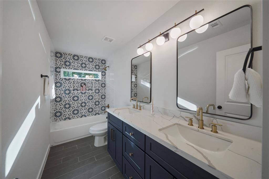 Secondary bath offers a tub/shower combo with high end finishes and dual sinks.