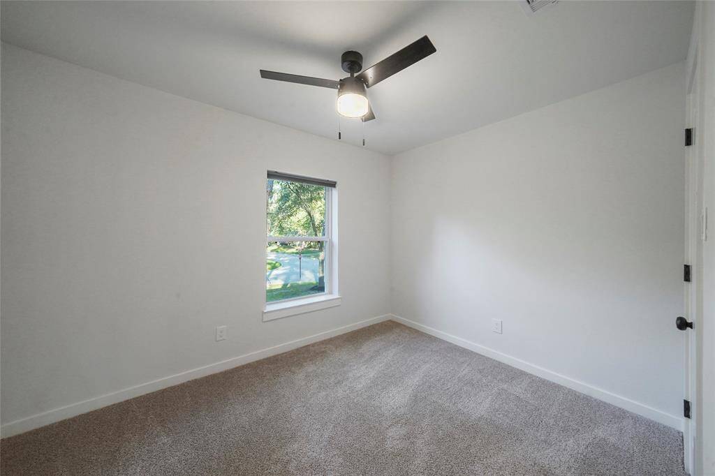 Bedroom #2 overlooking the front of the home with fan and walk-in closet.