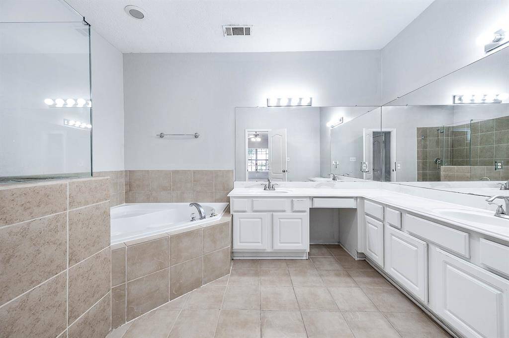 Primary bathroom boasting dual vanities, soaking tub and a separate shower