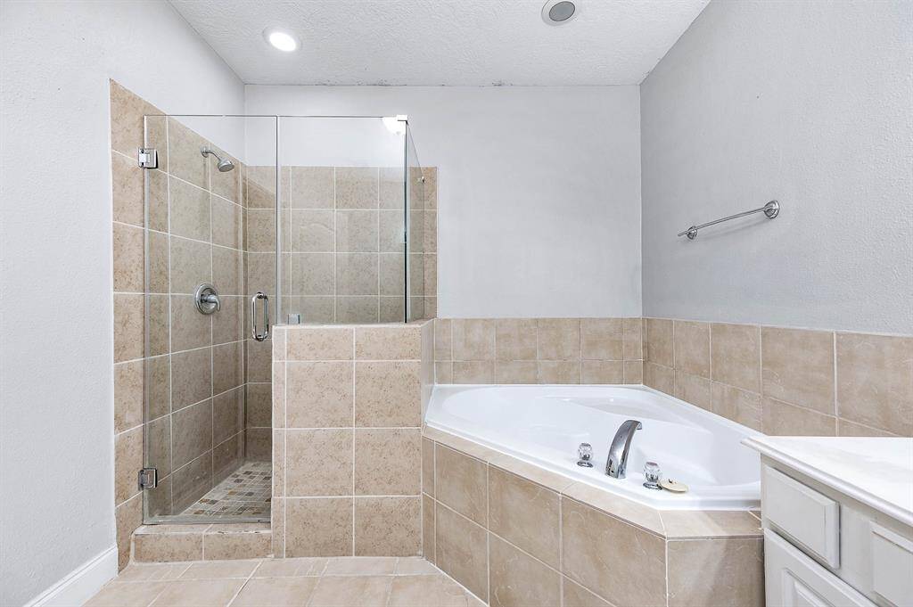 Primary bathroom boasting dual vanities, soaking tub and a separate shower