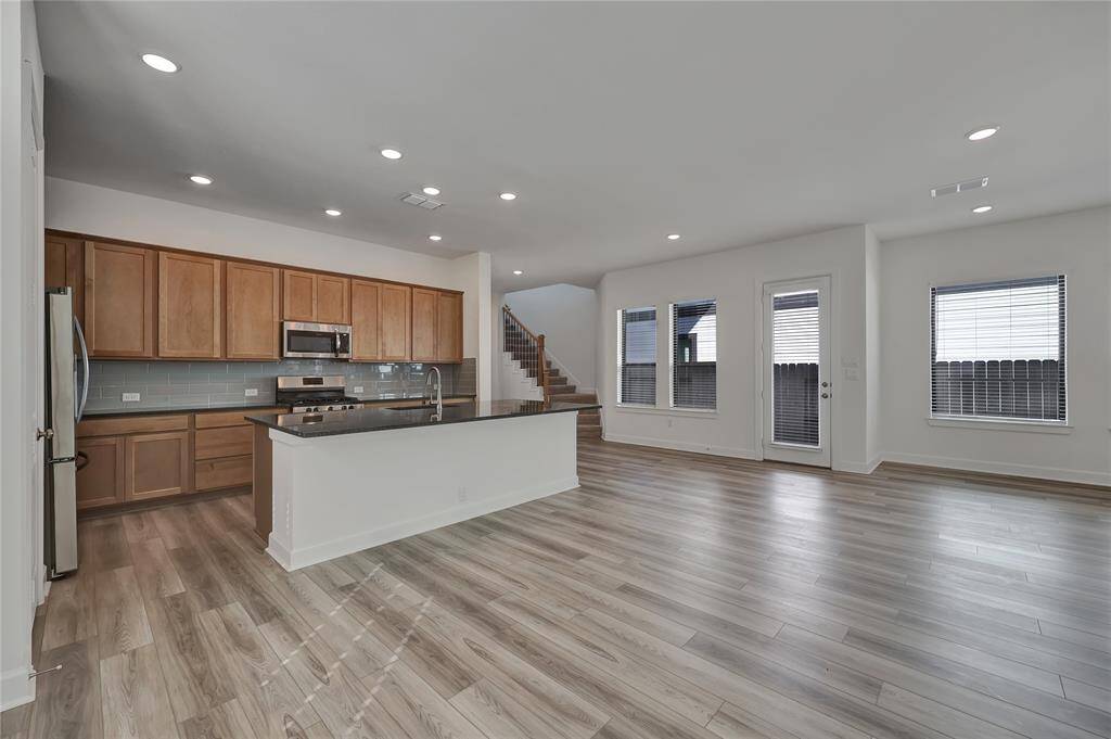 Right off the kitchen is access to the side yard leading to the spacious backyard.