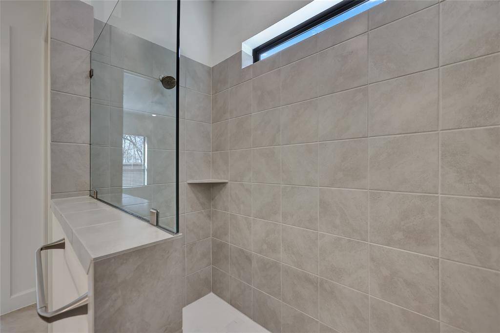The spacious walk-in shower features tile surround.