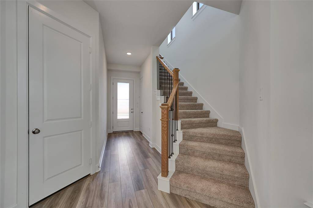 The staircase to the second floor features plush carpet and railing details!