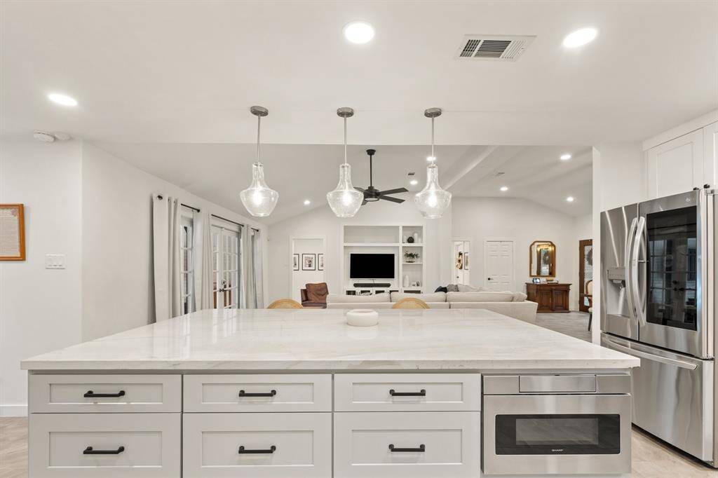 Massive island with a plethora of cabinets, incredible quartzite counters, new hardware, designer lighting, top of the line appliances, and a wide open view of the living room. This is the perfect place to entertain your friends and family.