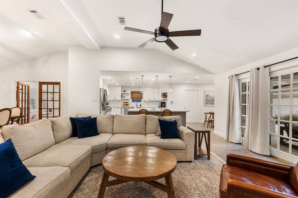 This spacious living room is the perfect setting for relaxation and socializing, offering plenty of room for family and friends to gather comfortably. With high ceilings, large windows, and ample seating, this space is an inviting atmosphere where everyone can feel at ease.
