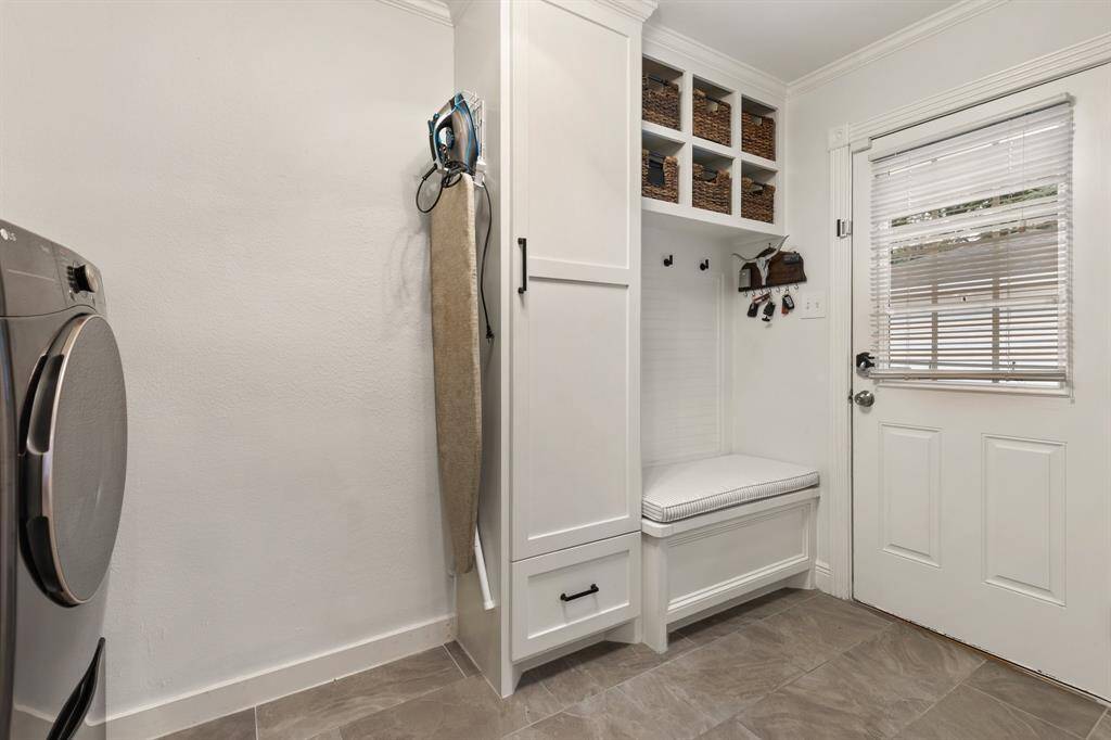 The utility room has been enhanced with custom cabinetry and clever storage solutions including a drop zone right next to the back door.