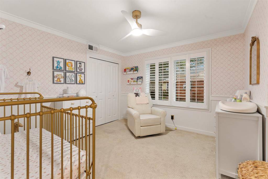One of two great sized secondary bedrooms with updated carpet, ceiling fan, designer wallpaper, wainscoting, and window shutters.