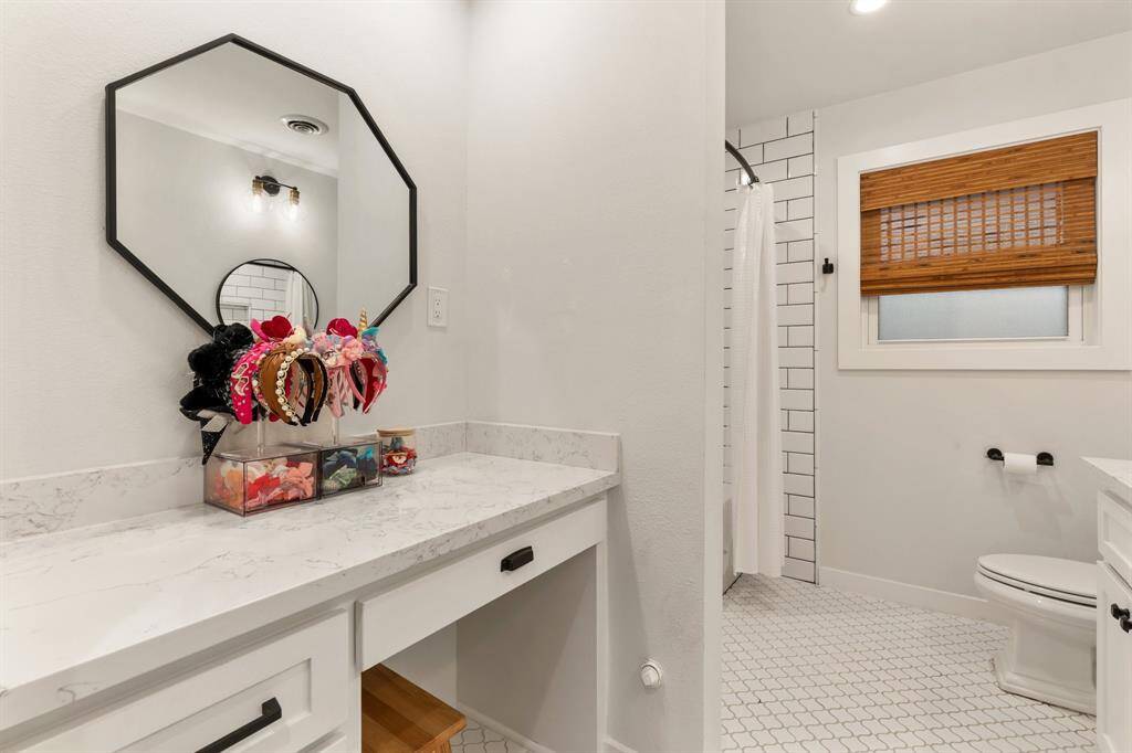 Across from the sinks is this built-in vanity counter space which adds to the functionality of this large secondary bathroom.