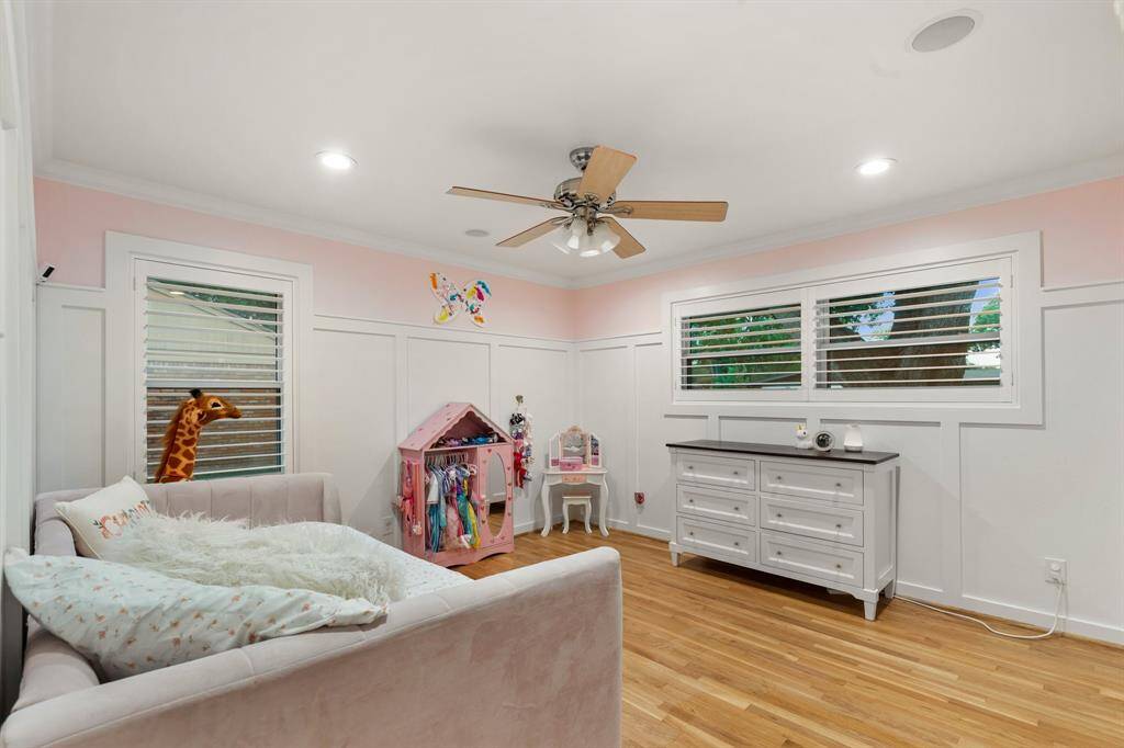 The third secondary bedroom offers gleaming refinished hardwood floors, window shutters, and gorgeous custom wainscoting.
