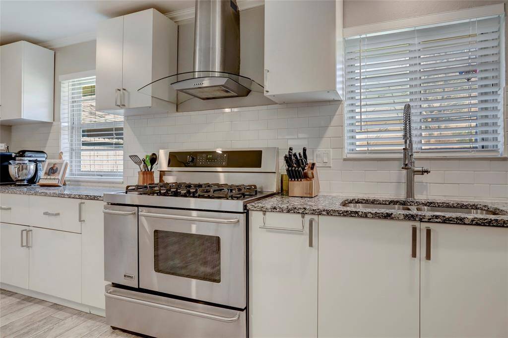 Granite countertops and white subway tile backsplash. Lots of upper and lower cabinets with brushed nickel hardware.