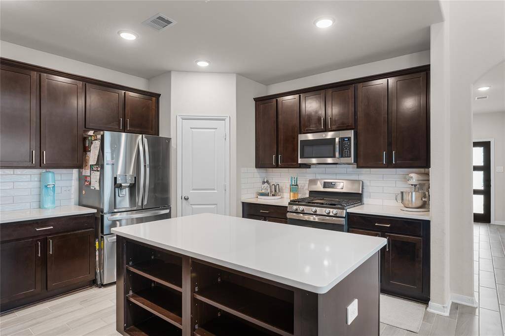 Closed cabinets on one side of the island and open storage on the other