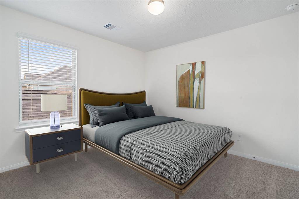 Secondary bedroom features plush carpet, neutral paint, lighting, a large window with privacy blinds and ample sized closet space.