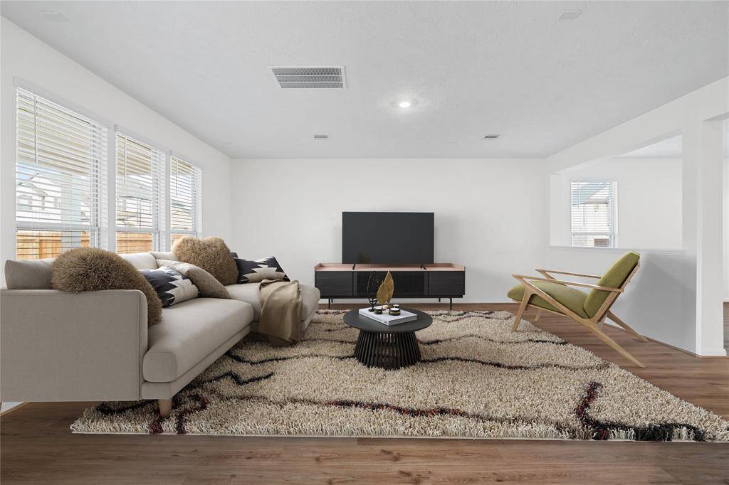 Gather the family and guests together in your lovely family room! Featuring high ceilings, recessed lighting, custom paint, gorgeous vinyl plank flooring, and a wall of windows that provide plenty of natural lighting throughout the day!