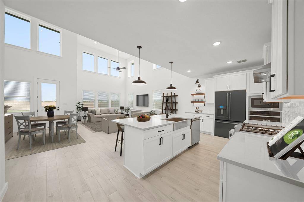 Island kitchen with white cabinets and quartz countertops