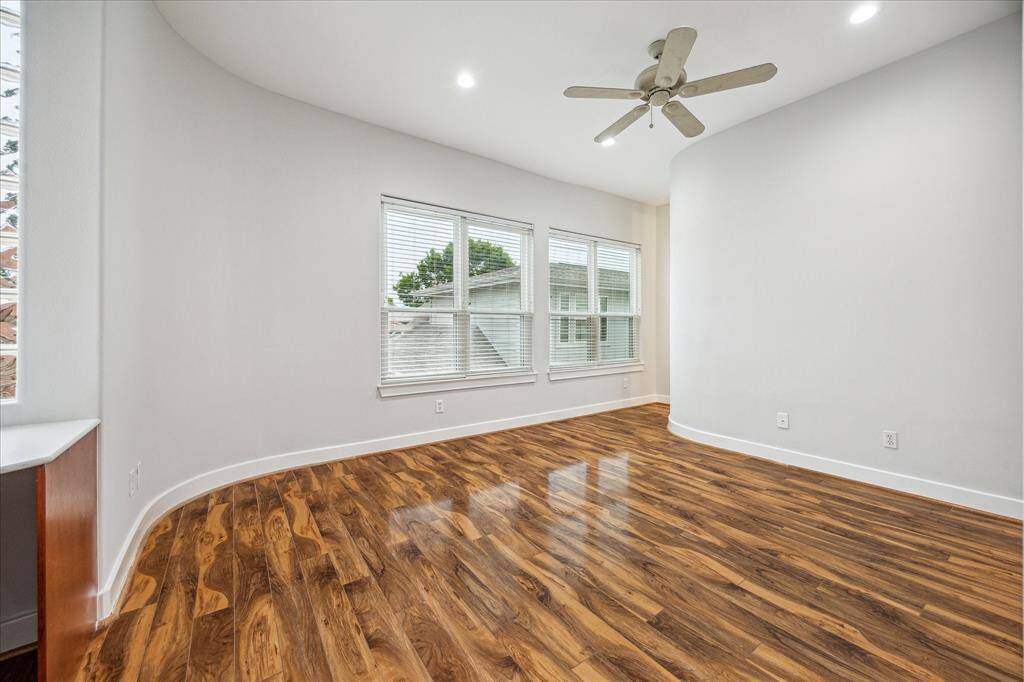 Primary bedroom with gleaming hardwoods and lots of natural lighting. 2" blinds in the bedrooms.