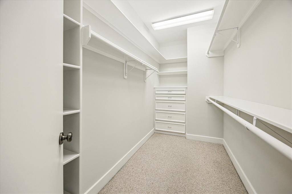 Spacious primary closet with built-in dresser and plenty of hanging space.