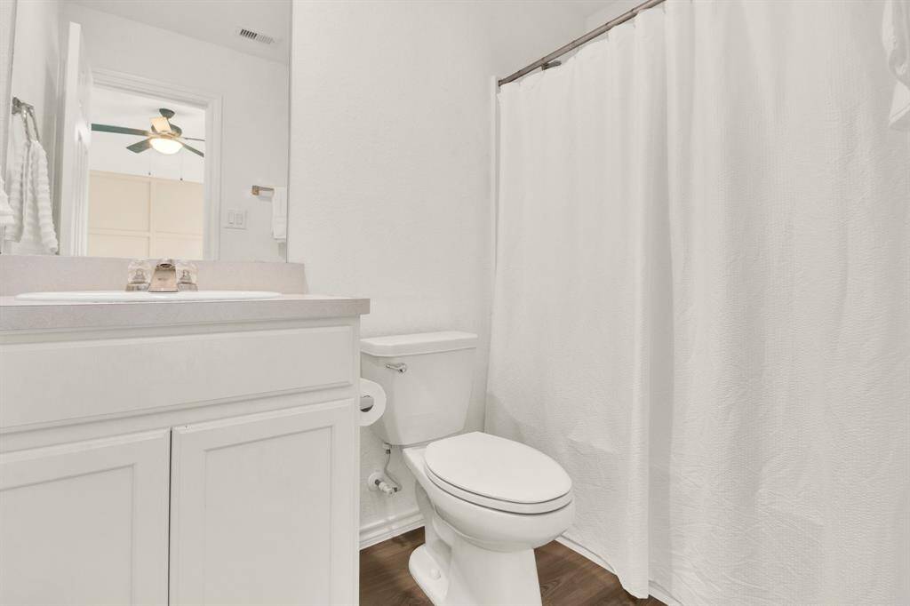 Clean, bright bathroom with a white vanity. The space is simple and well-lit, featuring a neutral color palette with modern fixtures.