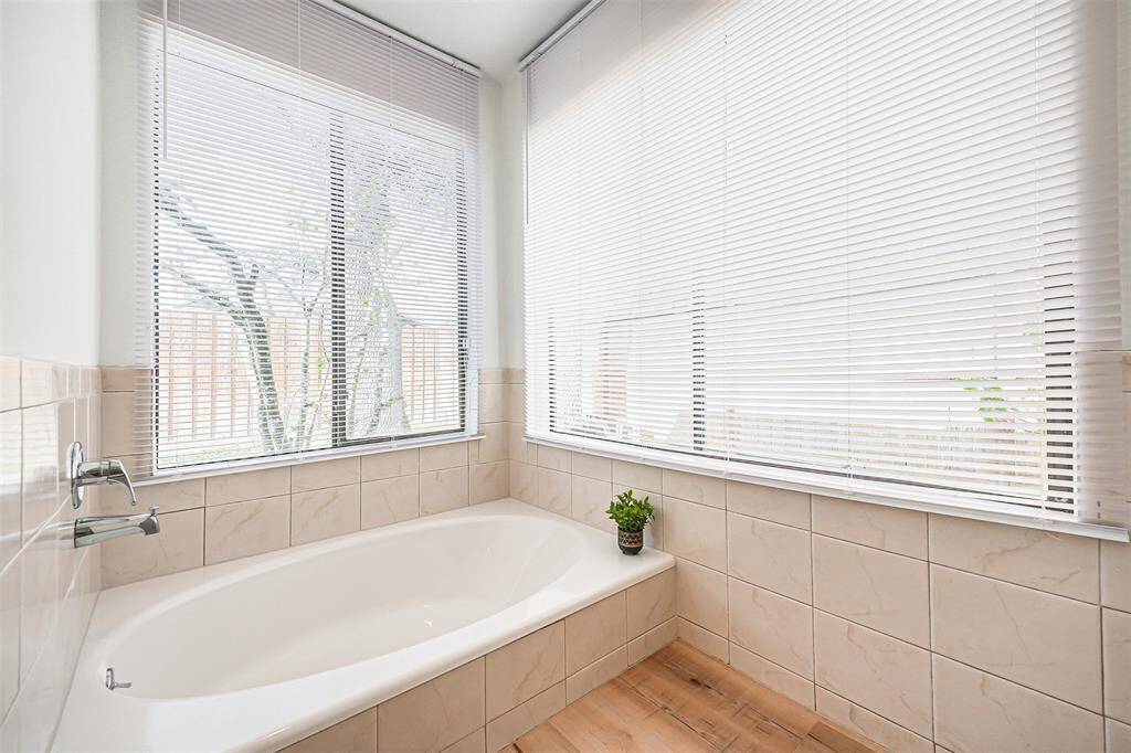 Large garden tub to relax in with tile surround in the Primary Bathroom Oasis
