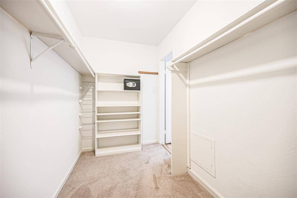 Large walk in closet with plush carpet and shelving for all your wardrobe needs