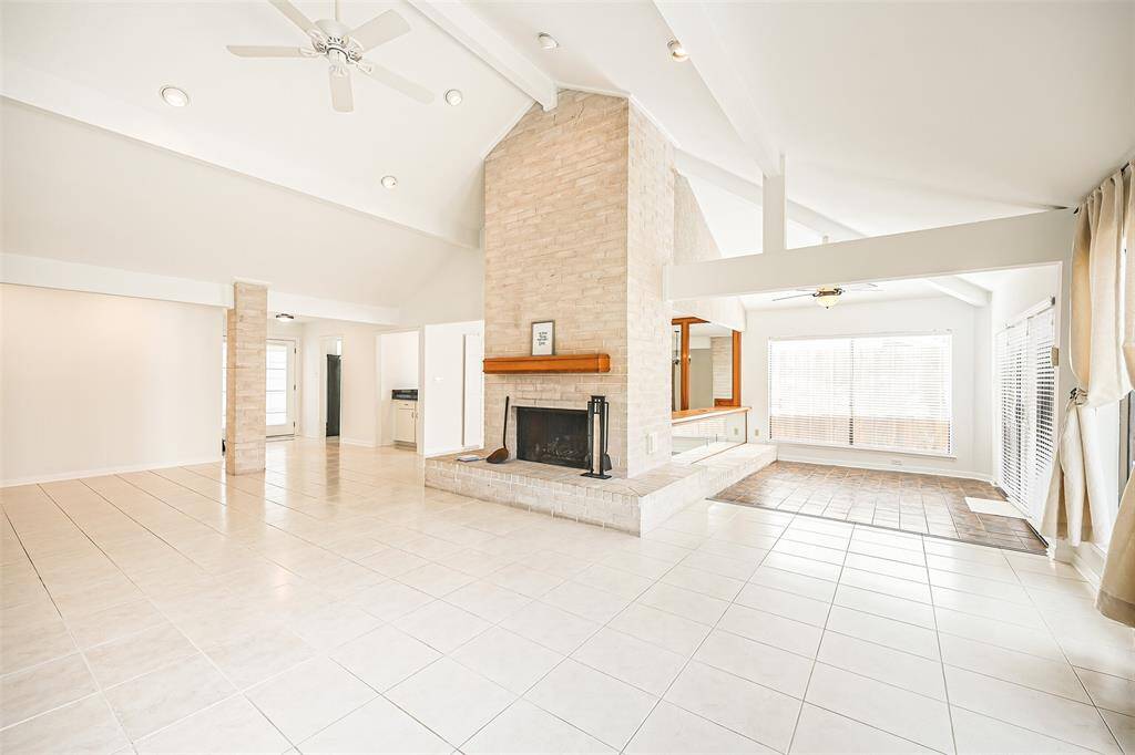 Large Living Room with terrific tile flooring, soaring ceilings and ceiling fan with lighitng to enjoy time with loved ones.