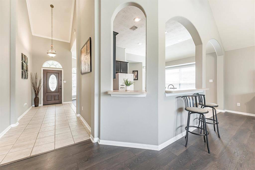 Arched openings around the kitchen add architectural flair and connect effortlessly to the spacious family room, creating an open layout perfect for entertaining and everyday living.