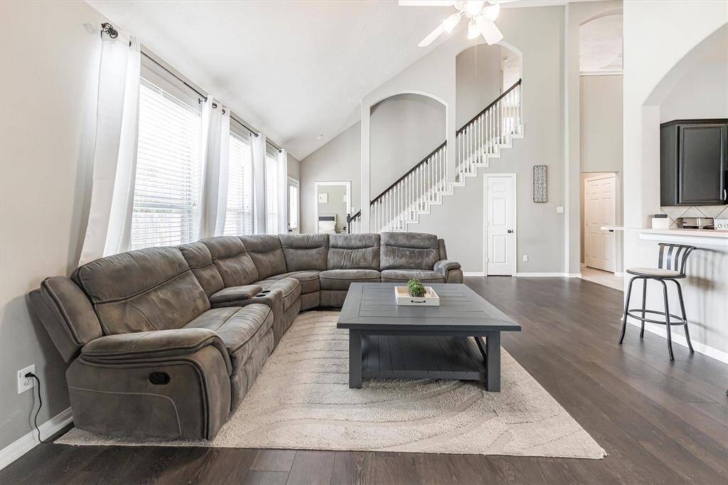 This light-filled family room brings the wow factor with soaring ceilings, sleek LVP flooring, and gorgeous arched openings that frame the staircase like a work of art. It’s the perfect hangout spot for cozy nights or lively get-togethers!