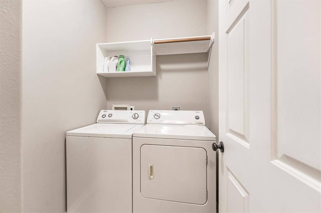 The utility room offers built-in shelving for storage and both gas and electric dryer connections.