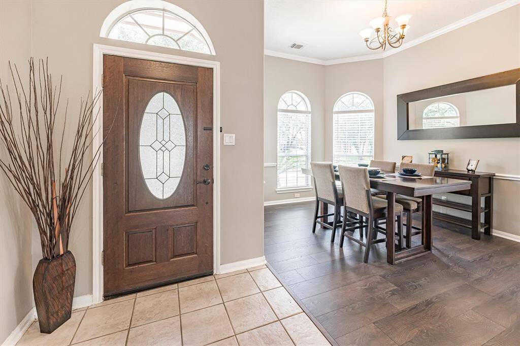 A lovely space to welcome guests, the foyer features an elegant wood and leaded glass door and previews of the formal dining room on the left and the spacious family room just ahead.