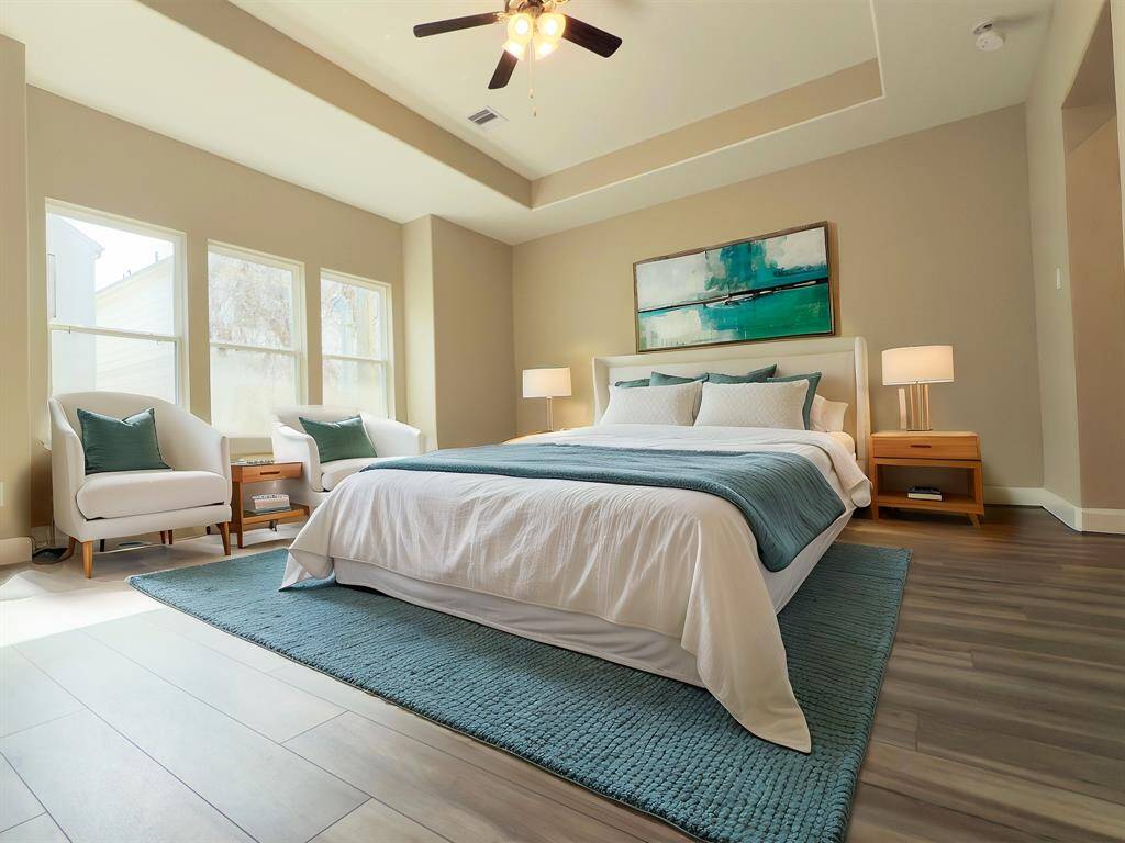 The ROCburne's primary bedroom is a luxurious retreat featuring a spacious layout, elegant furnishings, and ample natural light. Image depicts similar product at another ROC Homes community and is virtually staged.