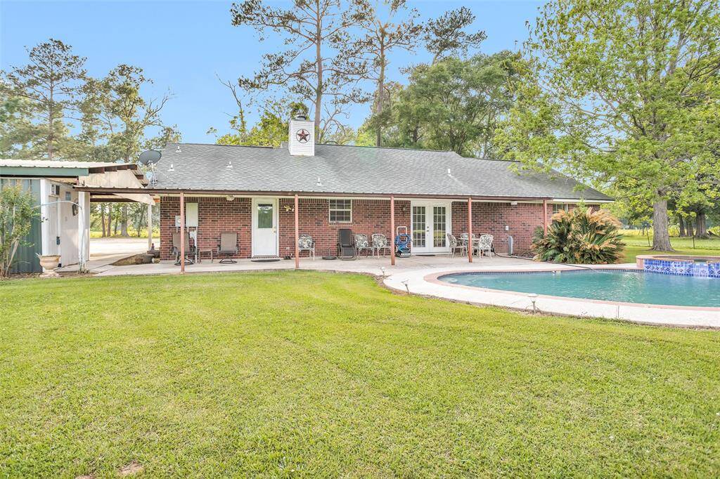 Back view of home with patio, pool and hot tub