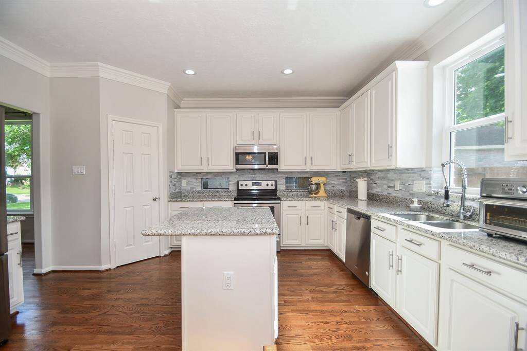 Wide open, easily navigable paths define the comfort and convenience of accomplishing tasks, here. Note the clever extended granite countertop on the center island. Some casual stools would be fine additions.