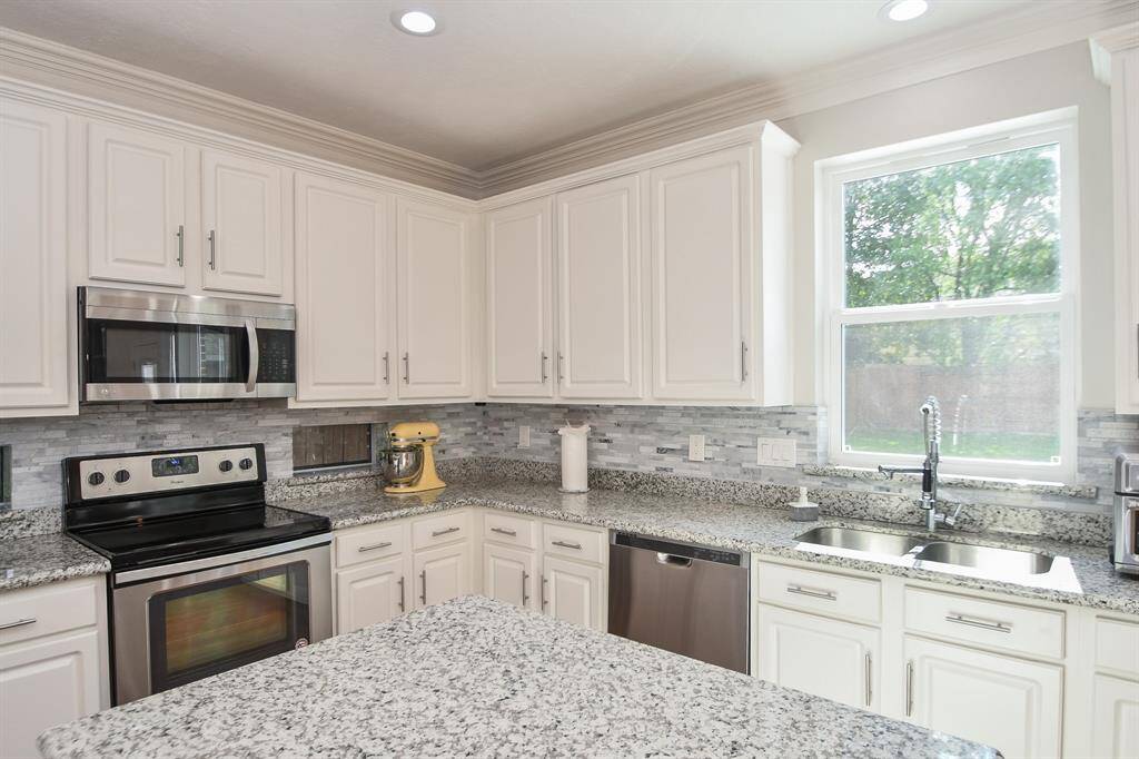 Tons of counter space, a large window over dual stainless steel sinks and glorious sunshine, make your time in this beloved space, a joy!