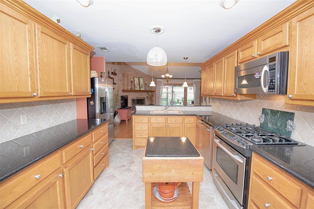 A view of the kitchen showing the fabulous storage, open to the family room and the island stays forr the lucky new owner. It features a granite counter too!