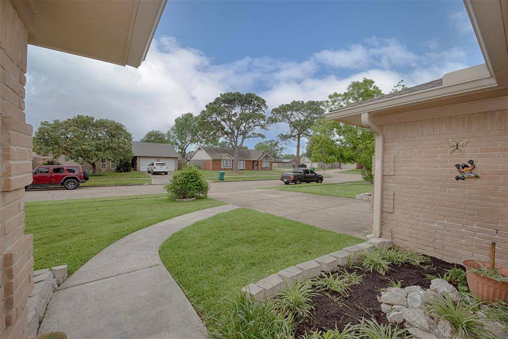 A view from the front porch showing the beautiful stone accented garden to the yard.