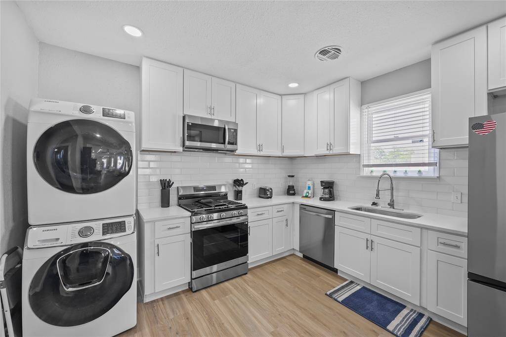 Bright and modern kitchen featuring white cabinetry and stainless steel appliances