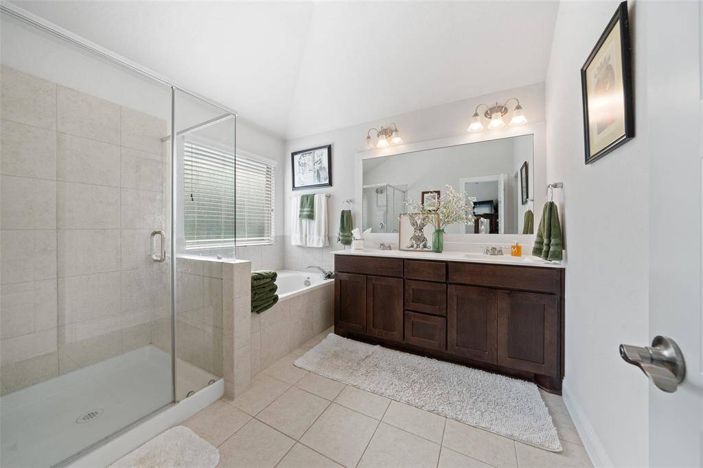Primary bath with dual sinks, soaking tub, and walk-in shower.