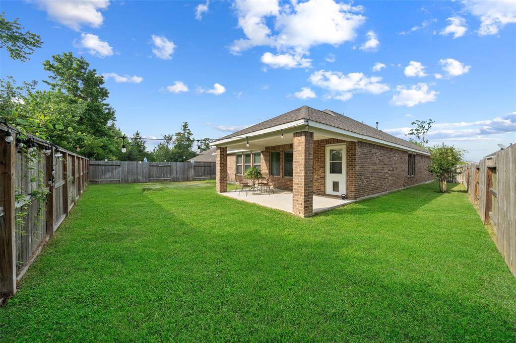 Spacious, fully fenced backyard with covered patio.