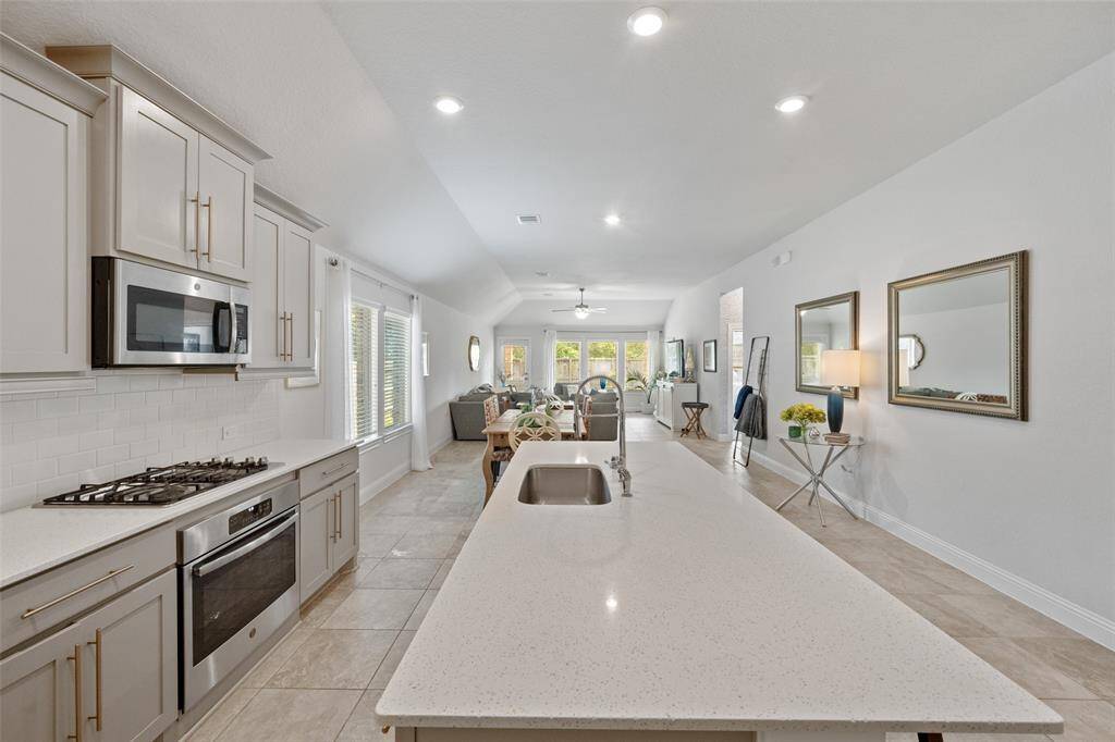 Notice the single basin sink, gleaming countertops, and gorgeous cabinetry.