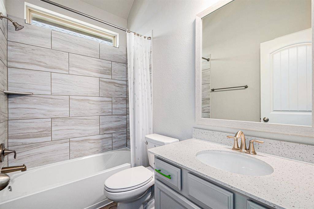 Secondary bathroom with a combination tub and shower offering both convenience and comfort for family and guests.
