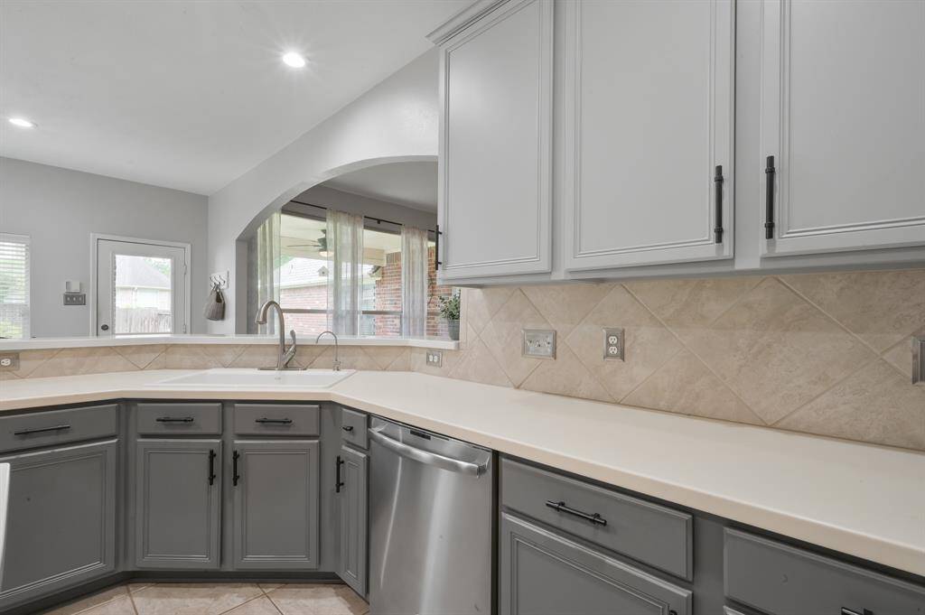 An updated farmhouse sink, faucet and dishwasher among a ton of cabinets means you can organize everything!