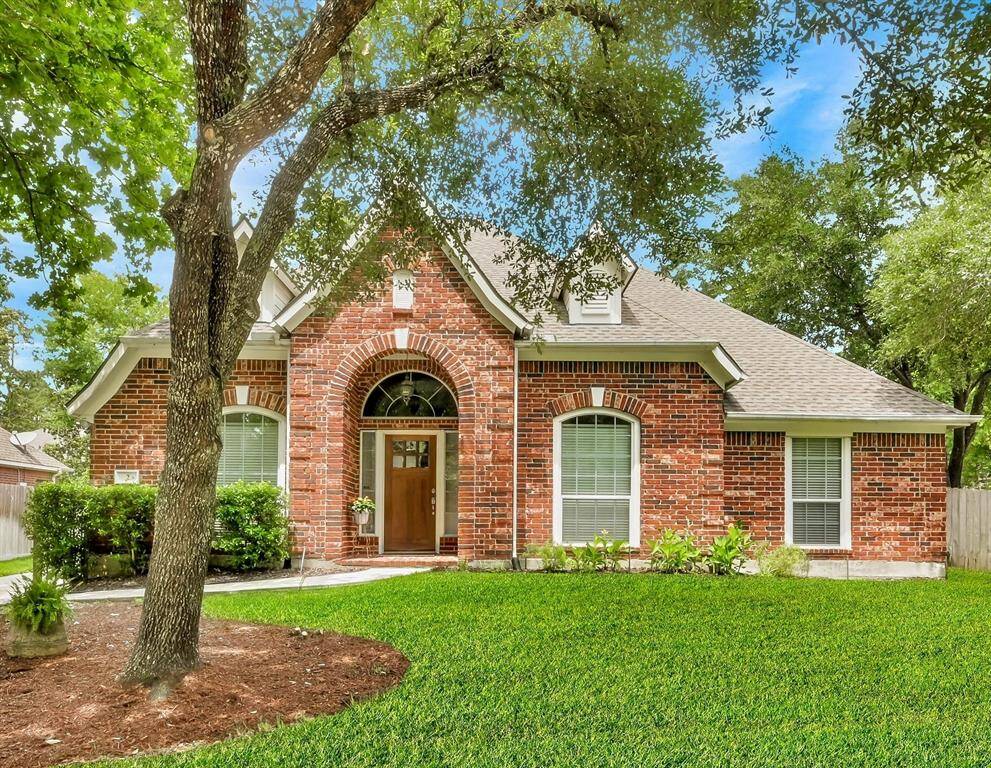 Stately Emerald Builders all-brick home has a welcoming arched entryway, well-maintained landscaping and lawn. Features large windows for ample natural light and an inviting exterior.