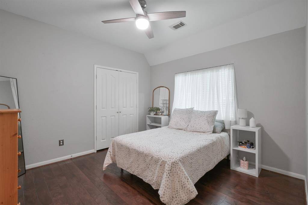 Bedroom 2 on first floor features neutral gray walls and wood floors for clean minimal look.