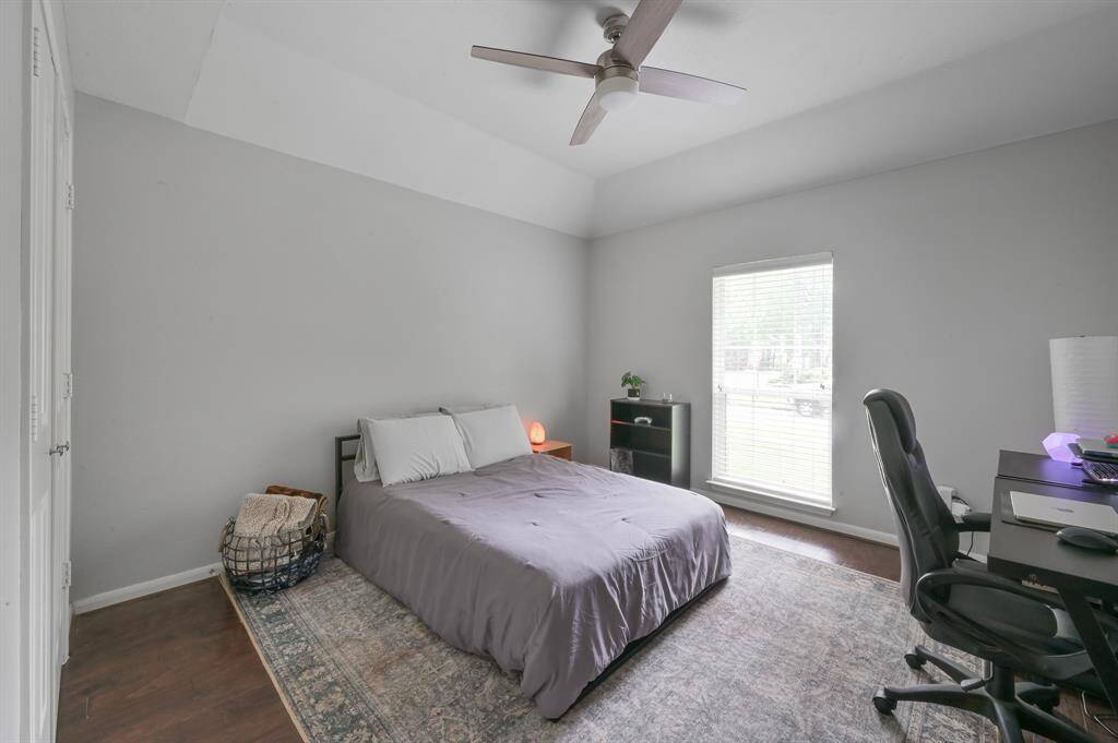 Bedroom 3 on first floor also features neutral gray walls and wood floors.
