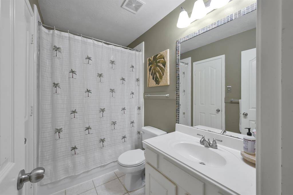 Bathroom 3 is on the second floor and features a clean and modern design with white vanity, neutral tone and tile flooring. Access to full Elfa custom closet within bathroom.