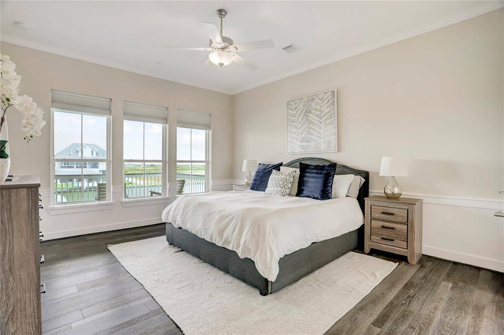 THE MASTER BEDROOM ISBRIGHT AND INVITING,FEATURING HARDWOODFLOORING AND 3 OVERSIZEDWINDOWS. IMAGINE WAKING UPTO THIS BEAUTIFUL VIEW!