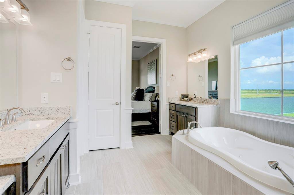 THIS VIEW OF THE MASTERBATHROOM SHOWCASES THETHOUGHTFUL LAYOUT OF THEBATHROOM TO THE MASTERBEDROOM. THE HUGE WINDOWNEAR THE TUB ALLOWS FORPLENTY OF NATURAL LIGHT,ENHANCING THE SENCE OFCALM AND RELAXATION IN THESPACE.