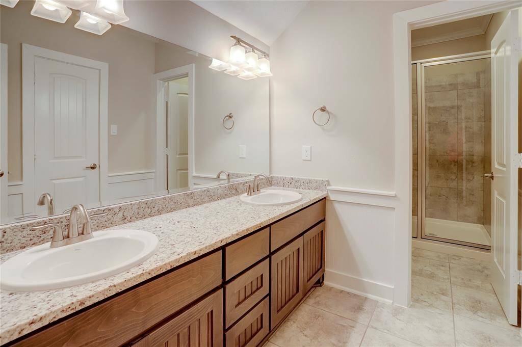 SPACIOUS SECONDARYBATHROOM FEATURES A DOUBLEVANITY WITH GRANITECOUNTERS, PROVIDING AMPLESPACE FOR MULTIPLE USERS.BATHROOM ALSO INCLUDES AGLASS ENCLOSED,