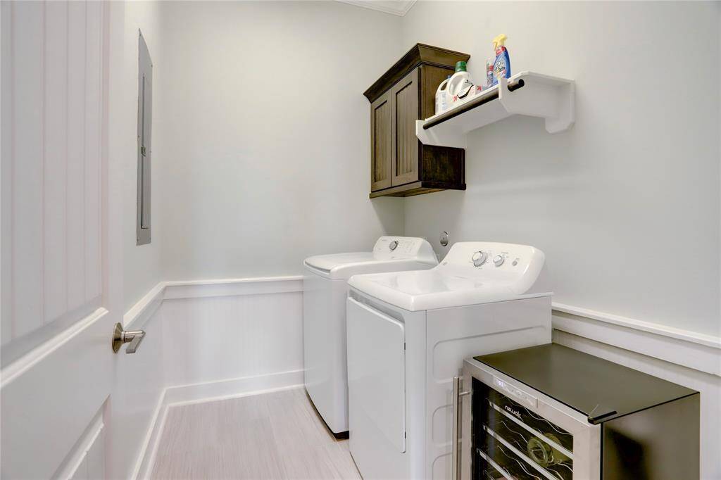 SPACIOUS LAUNDRY ROOMINCLUDES A HANGING CABINETAND BUILT-IN ROD PROVIDINGSTORAGE SPACES FORLAUNDRY SUPPLIES.