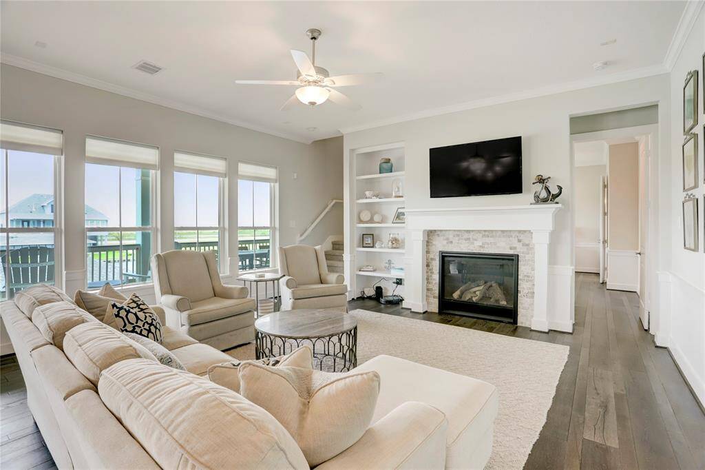 FAMILY ROOM FEATURES A COZYFIREPLACE WITH A STONEMANTLE AND BUILT-IN SHELVES.THE WINDOWS PROVIDEEXPANSIVE VIEWS, ADDING TOTHE OPENNESS ANDTRANQUILITY OF THE HOME.